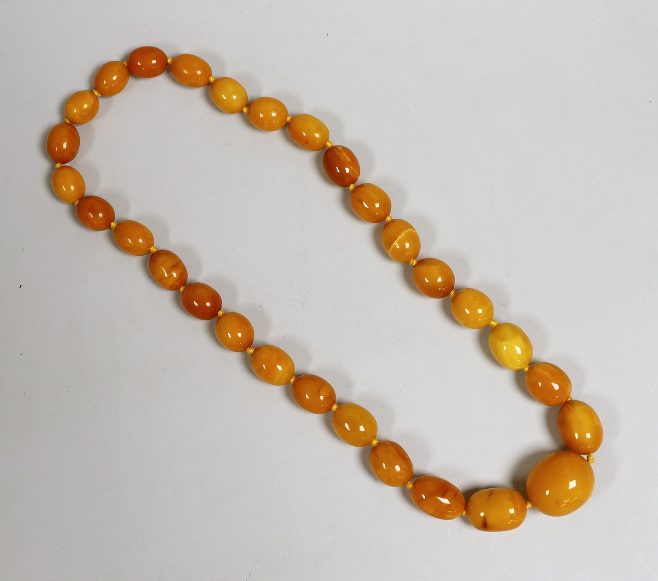 A single strand graduated oval amber bead necklace, 64cm, gross weight 113 grams.